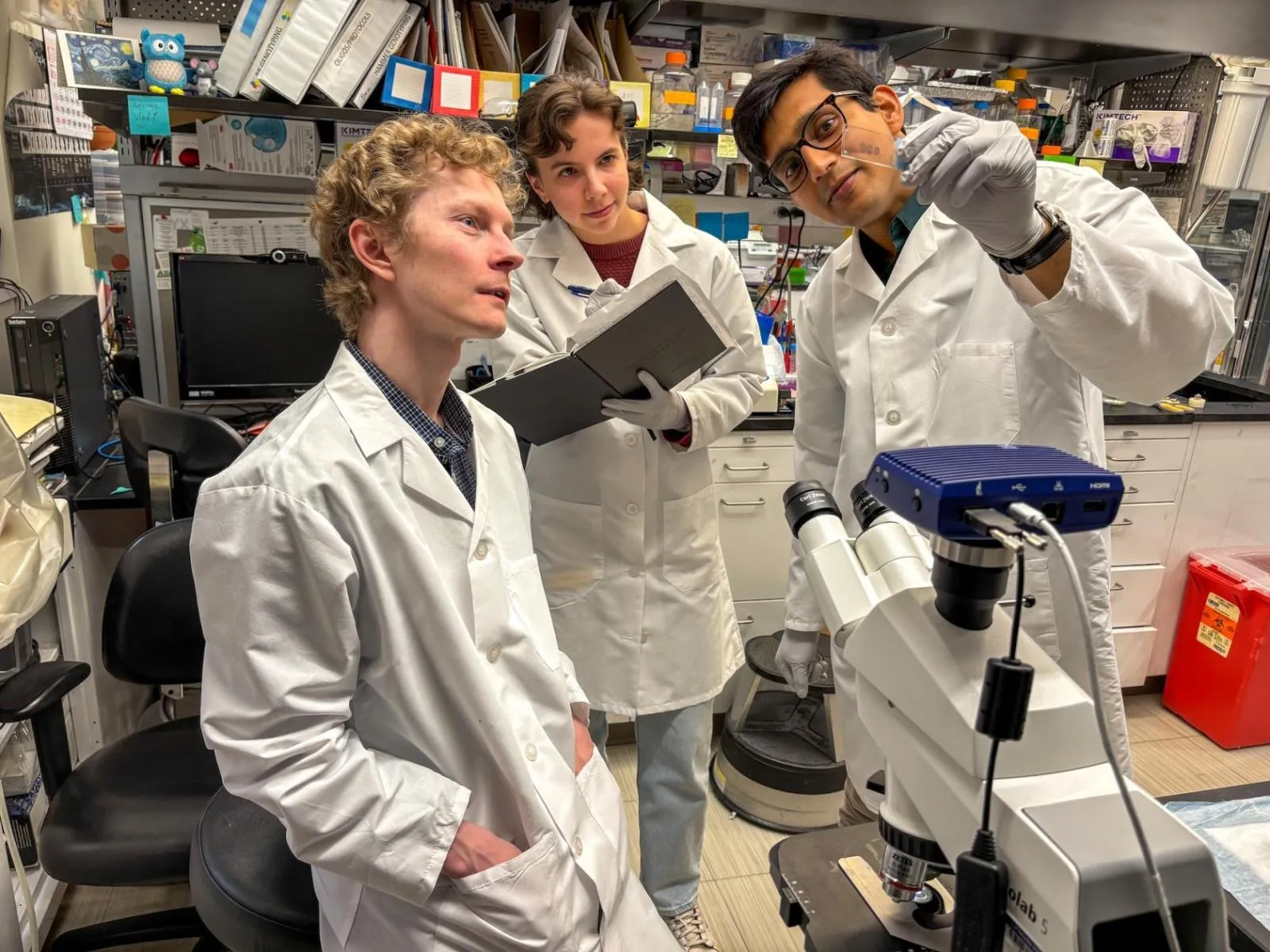 Study co-authors Vlad Korobeynikov (left, neuropathology fellow), Olivia Rifai (center, postdoctoral fellow), and Mahabub Alam (right, PhD student), in the laboratory. Photo by Columbia University Irving Medical Center. 